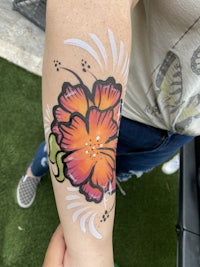 a woman with a flower tattoo on her arm