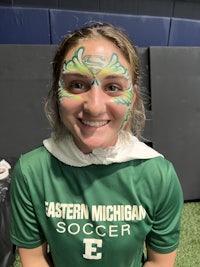 a girl in a green shirt with green paint on her face