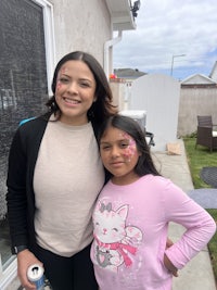 two young girls posing for a picture in front of a house